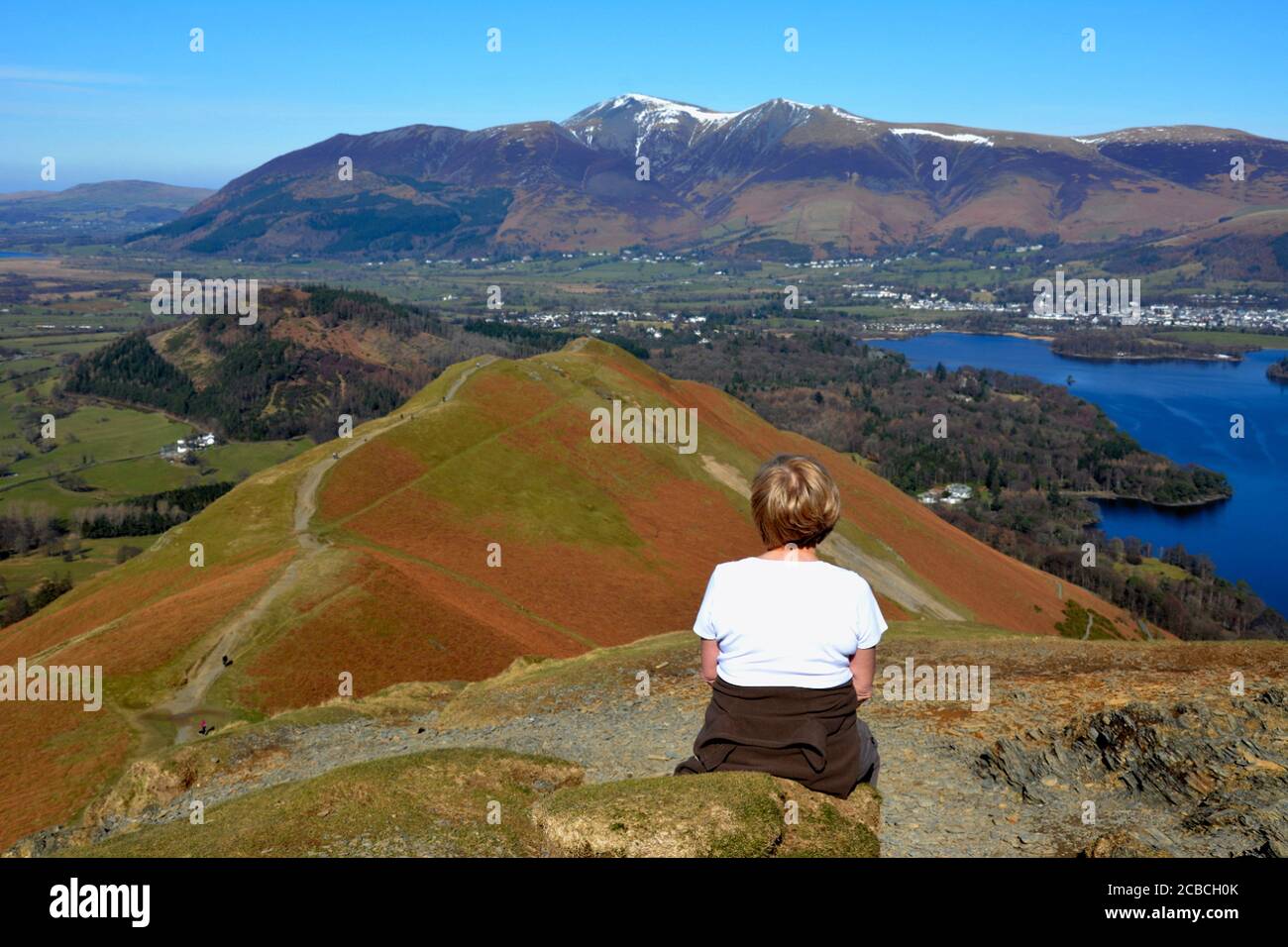 Frau mit Blick auf den Aufstieg von Cat Bells, Cumbria, Großbritannien Stockfoto