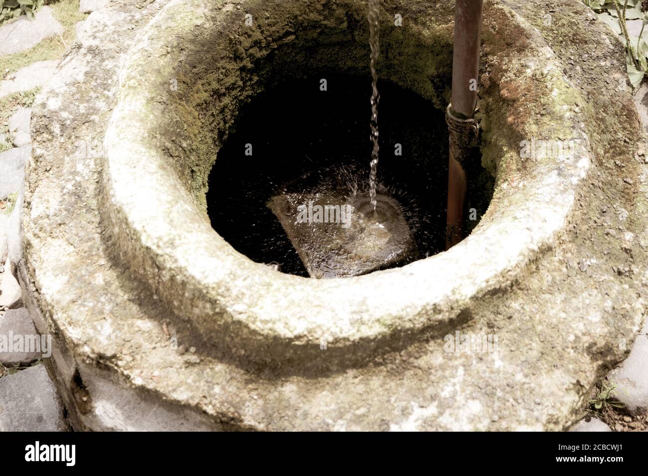 Sehr alter Brunnen, in dem sauberes Wasser fließt. Das Hotel liegt im Hof eines Landhauses Stockfoto