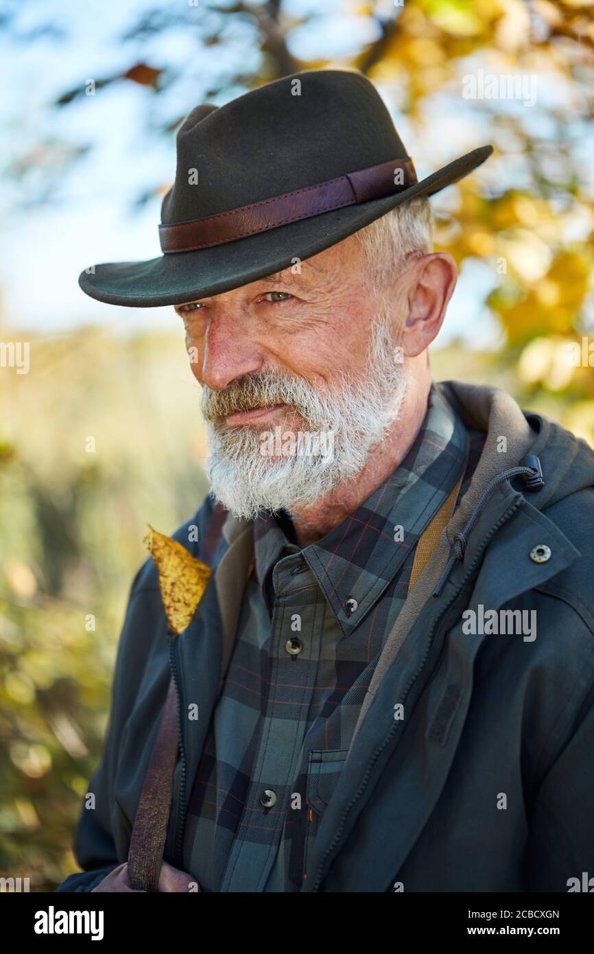 Waldjagd auf Tiere. Älterer Mann mit Schrotflinte, schaut weg. Aufgeregt nach der Jagd im Wald Stockfoto