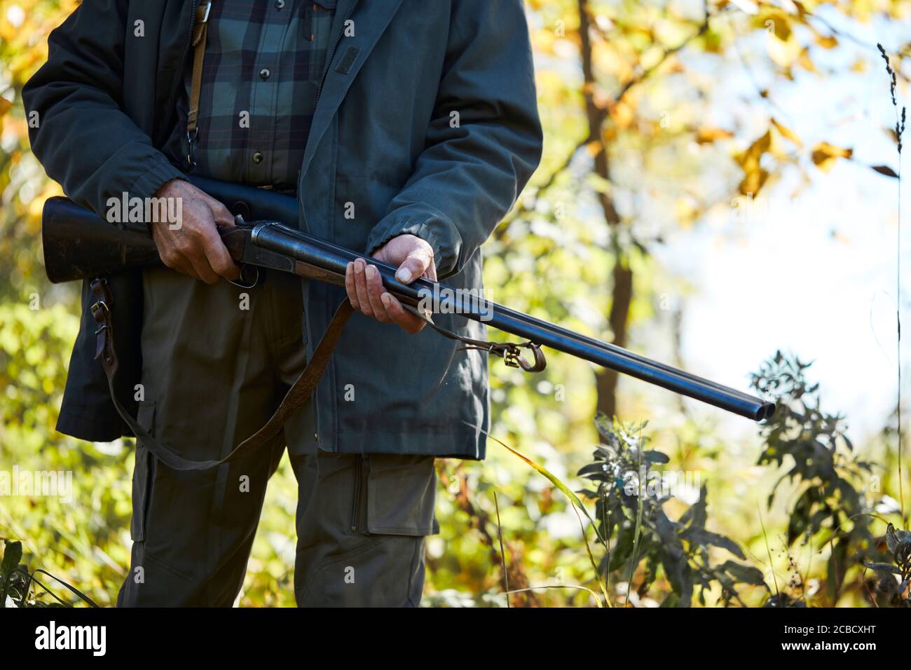 Waldjagd auf Tiere. Älterer Mann mit Schrotflinte, geht zur Jagd Stockfoto