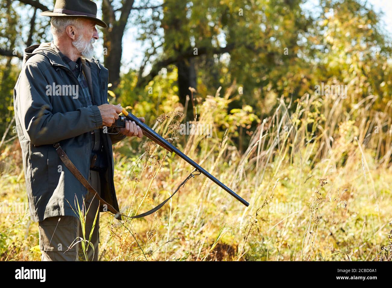 Ältere Mann schauen weg auf der Suche nach Trophäe Laden Gewehr gehen auf wilde Tiere zu schießen. Jagd als Hobby Stockfoto