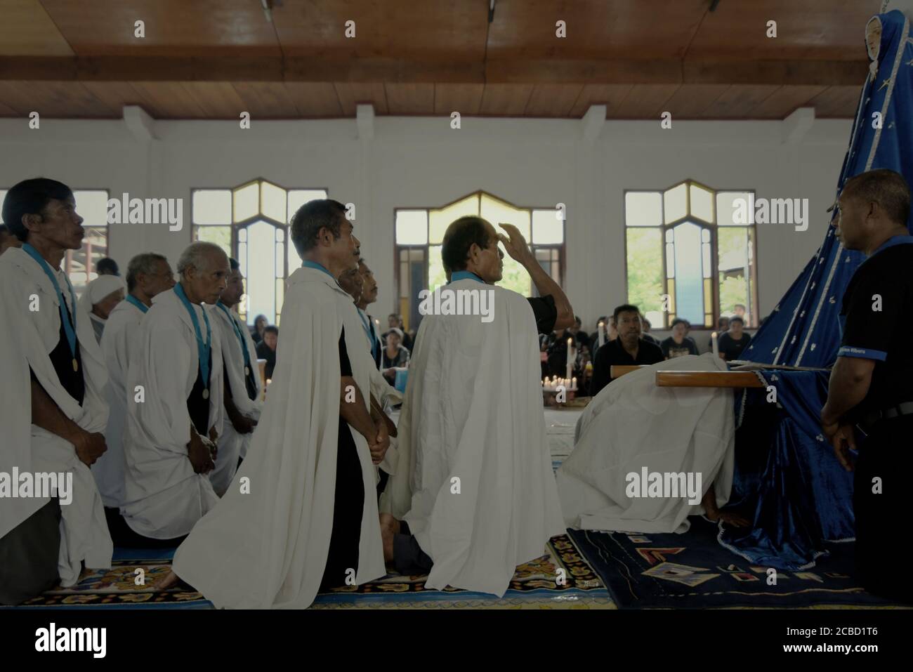 Larantuka, Indonesien. April 2015. Älteste der katholischen Kirche stehen vor einer alten Mutter-Maria-Statue, die traditionell als Tuan Ma am Gründonnerstag in der Tuan Ma-Kapelle bekannt ist, als Teil der Feierlichkeiten der Karwoche in Larantuka, Flores Island, Indonesien. Stockfoto