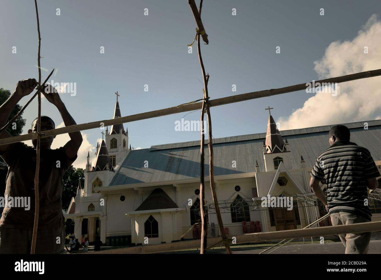 Larantuka, Indonesien. April 2015. Mitglieder der Kirchengemeinde arbeiten am Karmittwoch vor der Kathedrale von Larantuka zusammen und bauen einen Bambuszaun als Plattform, um Kerzen für die Prozessionen der Karwoche in Larantuka, Insel Flores, Indonesien, zu errichten. Stockfoto
