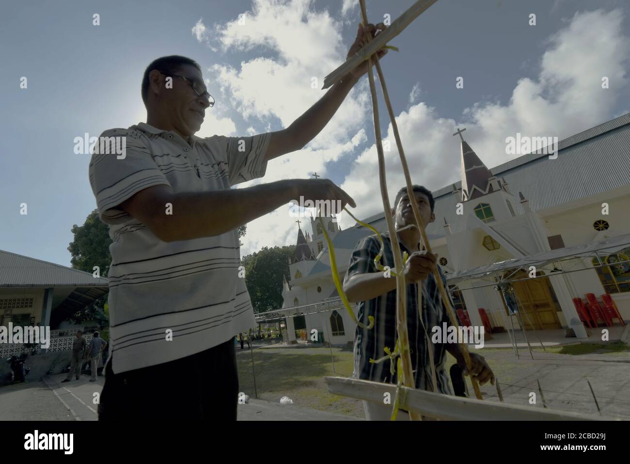 Larantuka, Indonesien. April 2015. Mitglieder der Kirchengemeinde arbeiten am Karmittwoch vor der Kathedrale von Larantuka zusammen und bauen einen Bambuszaun als Plattform, um Kerzen für die Prozessionen der Karwoche in Larantuka, Insel Flores, Indonesien, zu errichten. Stockfoto