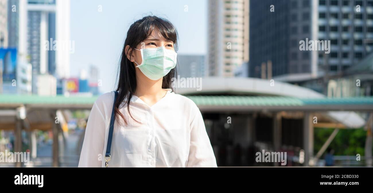 Banner der asiatischen Geschäftsfrau in weißem Hemd gehen, um in Verschmutzung Stadt zu arbeiten trägt sie Schutzmaske verhindern PM2.5 Staub, Smog, Luftverschmutzung und COV Stockfoto