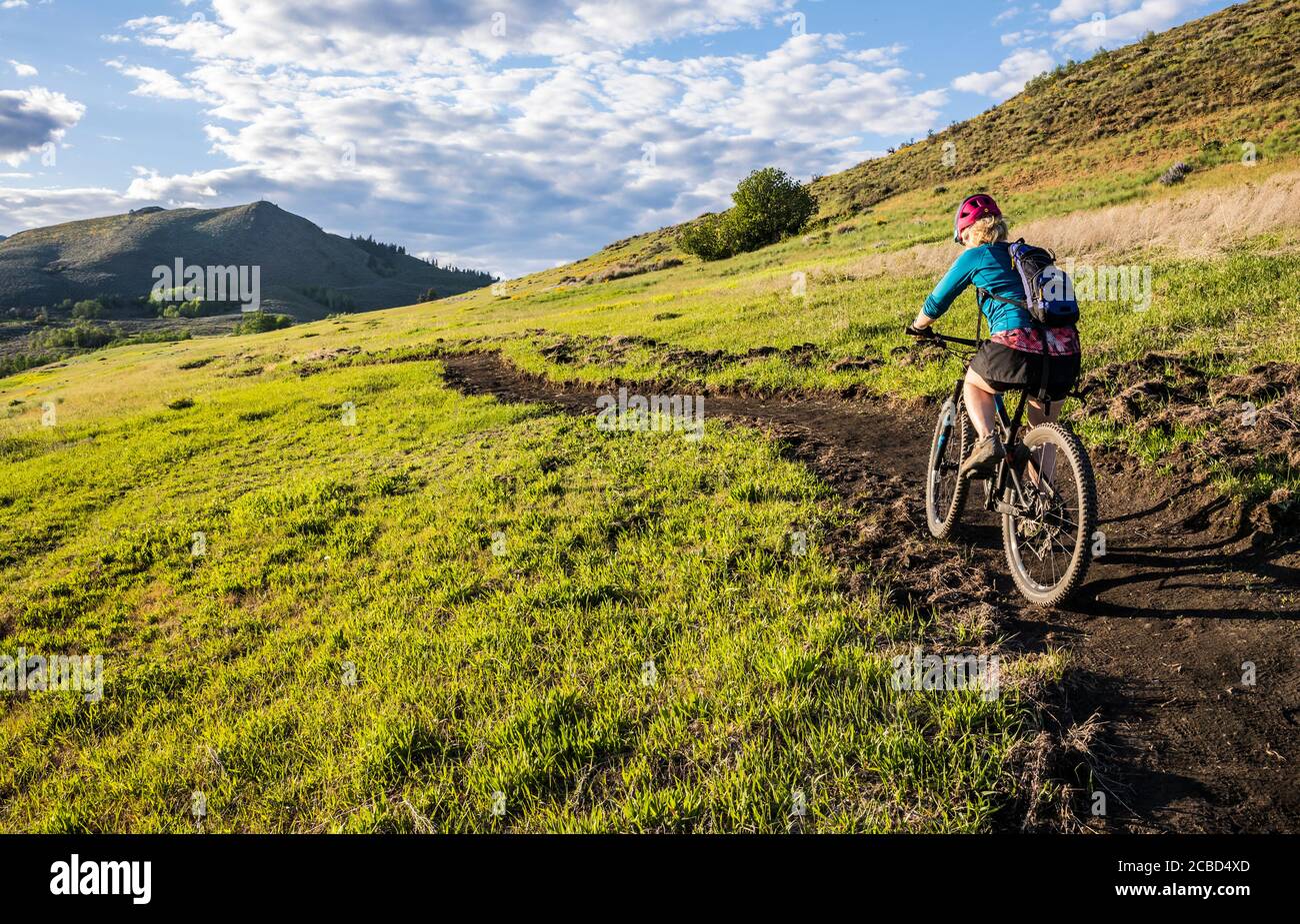 Eine Frau, die an einem sonnigen Nachmittag im Mai den Trail auf Lewis Butte außerhalb von Winthrop, Washington, bestieg. Stockfoto