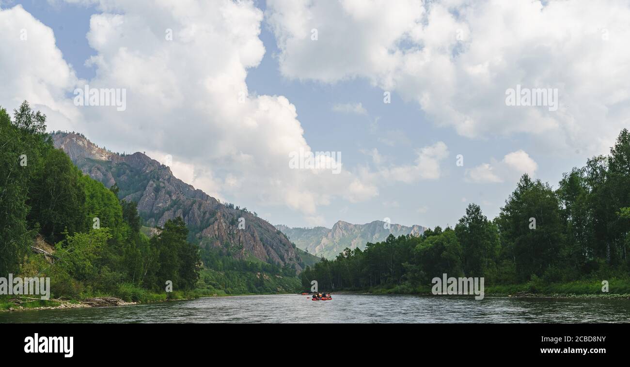 Weißer Fluss Iyus zwischen Hügeln und Felsmassiven. Menschen treiben den Fluss auf Katamaranen hinunter. Russland, Chakassien. Stockfoto