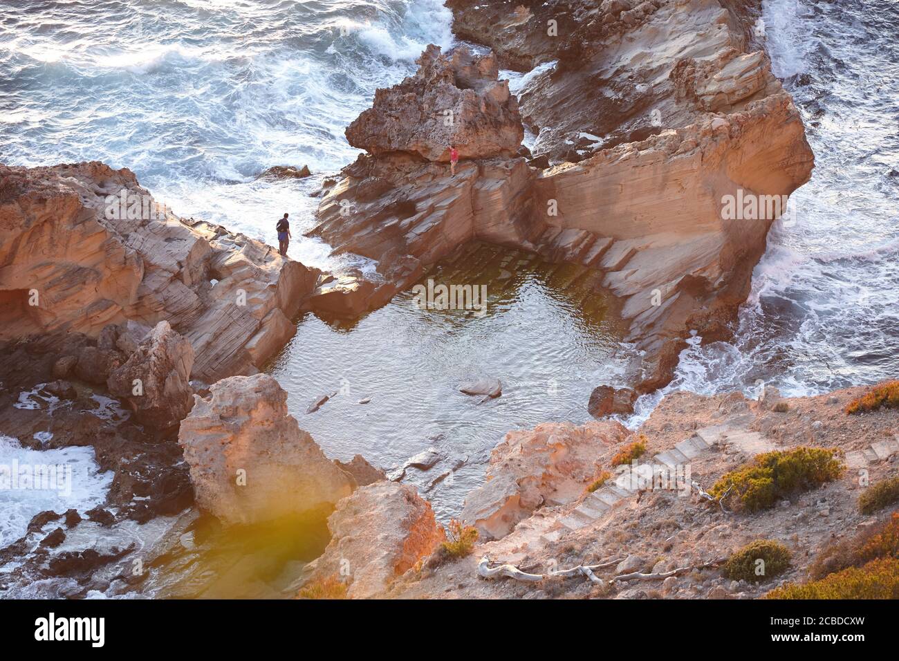 Pärchen auf den Felsen knah am Meer mit Sonnenlicht Stockfoto