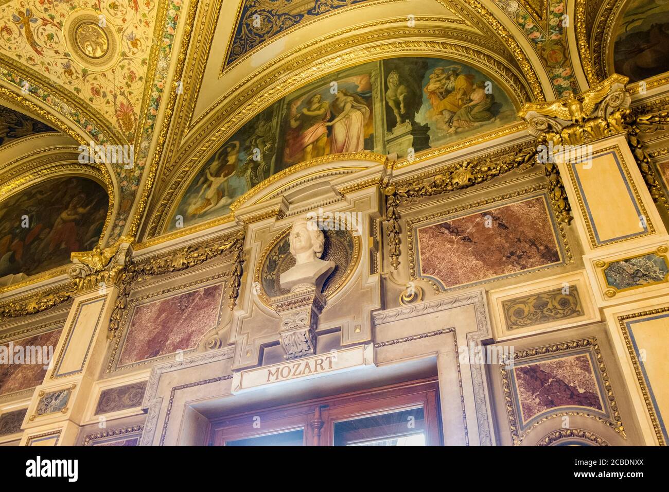 Goldene Lobby-Wanddetails von Mozart und Gemälden an der Wiener Staatsoper und der Staatsoper. In Wien, Österreich. Stockfoto