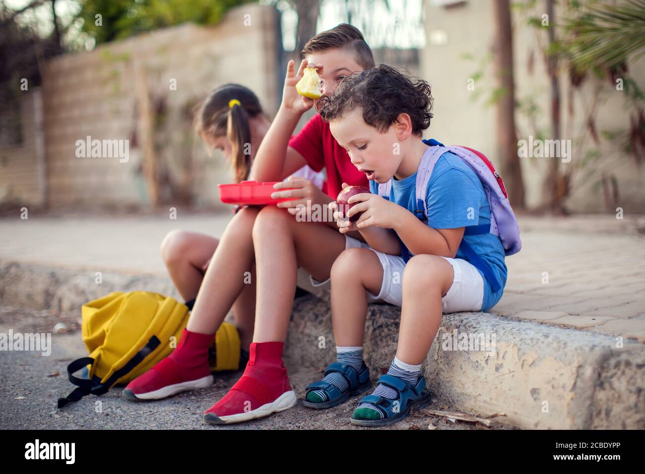 Schüler, die einen Snack im Freien. Kinder, Bildung und Ernährung Konzept Stockfoto