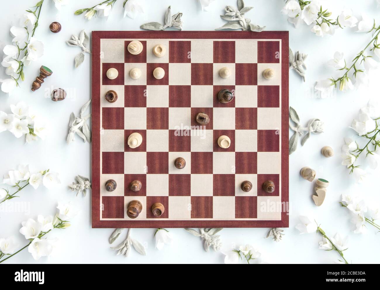 Styled hölzerne Schachspiel-Szene mit Blumen, Schach-Puzzle, opfern  Königin, flach legen, Blick von oben, kreative Styling Stockfotografie -  Alamy