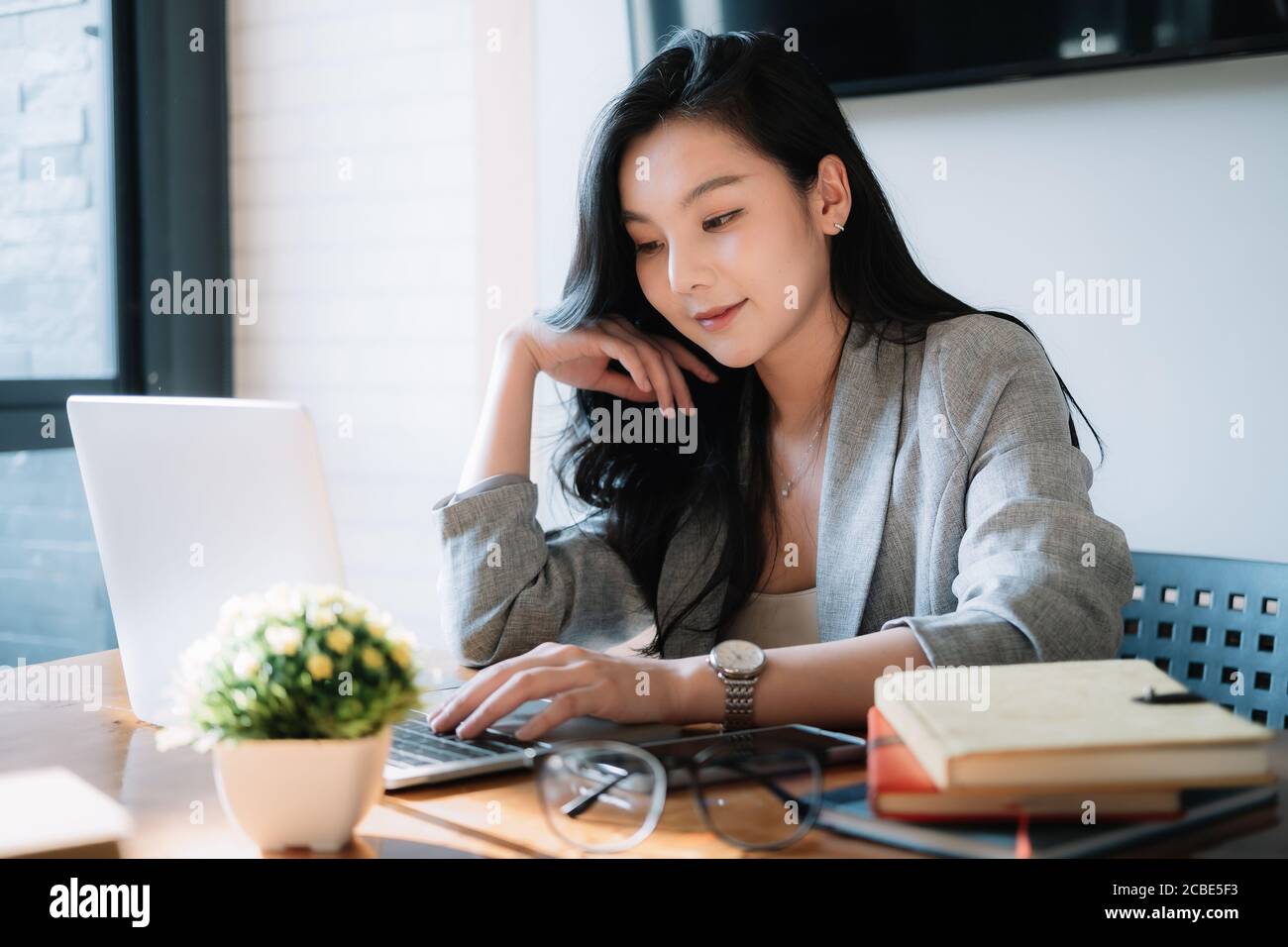 Portrait Junge asiatische Mädchen arbeiten bei ein sie Büro mit Ein Laptop-Computer Stockfoto