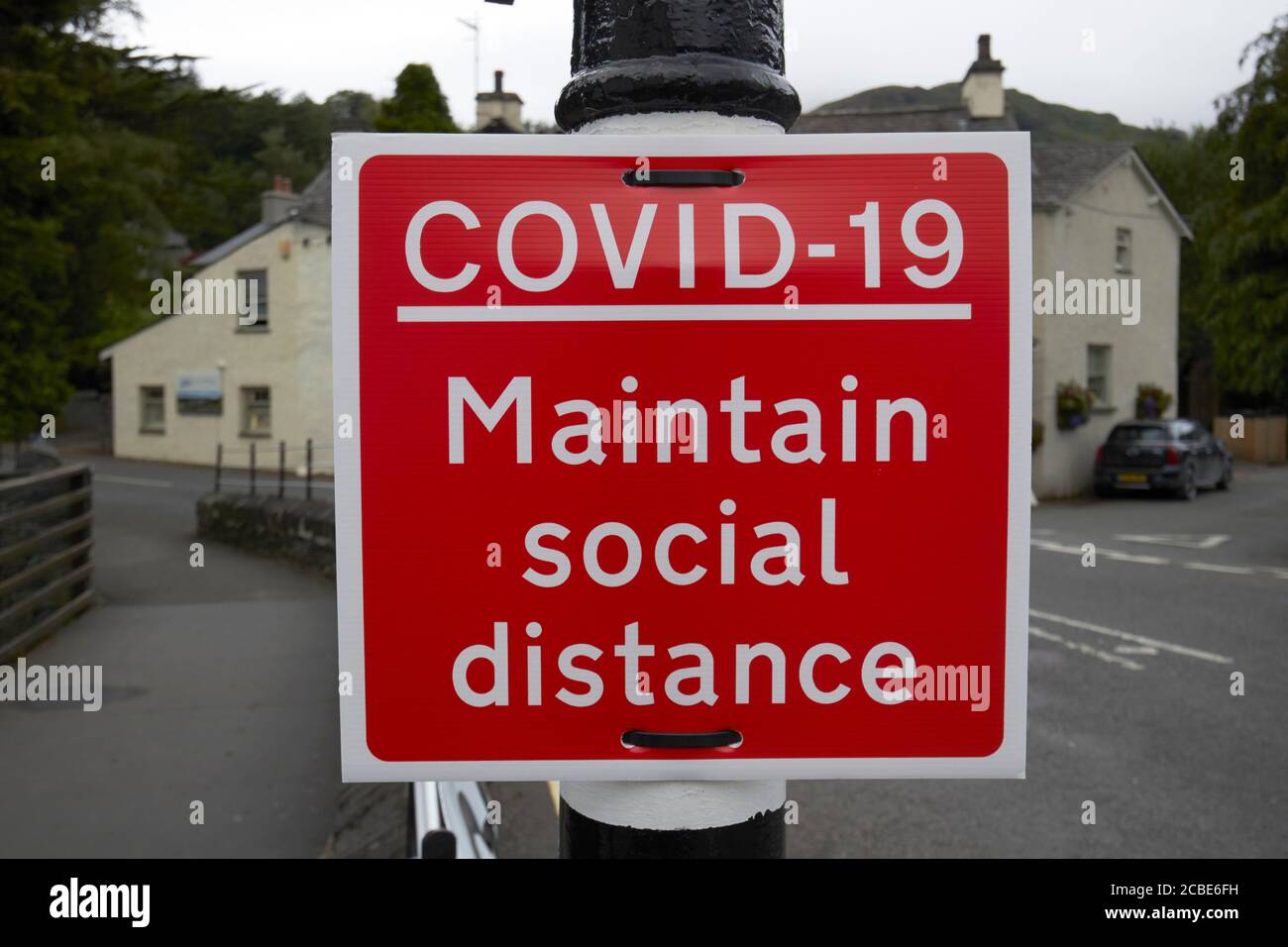 Rotes Warnschild auf der Straße für Maßnahmen, die in Kraft gesetzt wurden Für die soziale Distanzierung während des Covid-19 Coronavirus-Ausbruchs in der lake District cumbria engla Stockfoto