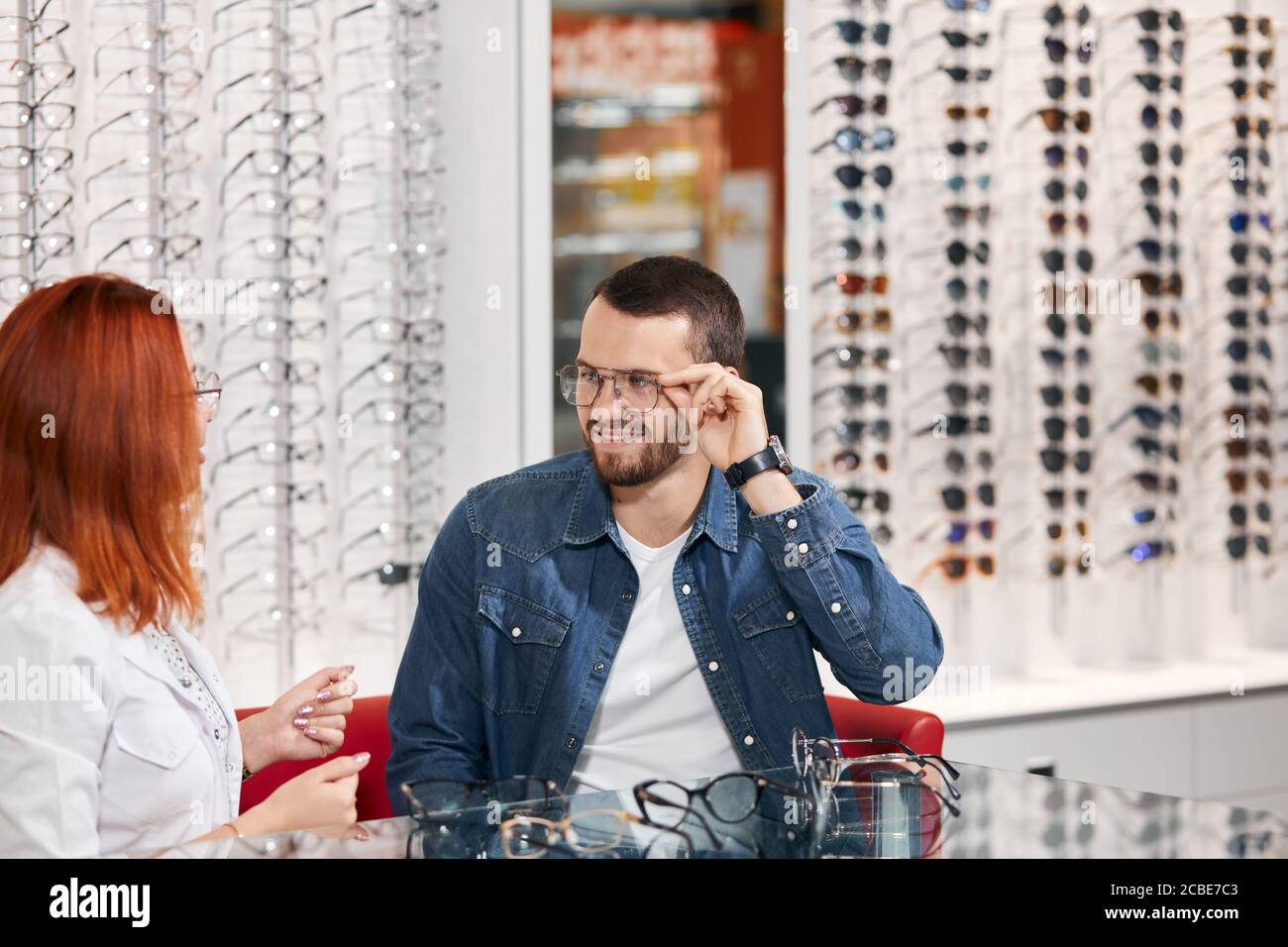 Professionelle Ingwer Optiker beraten zu einem Mann, Nahaufnahme Foto, Beruf. nach oben schließen Foto Stockfoto