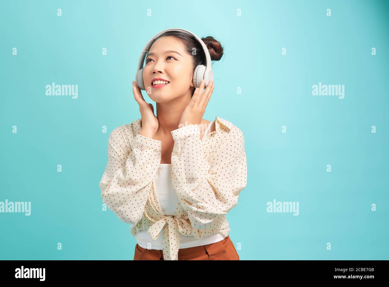 Frau mit Kopfhörern Musik hören . Musik Teenager Mädchen tanzen gegen blau. Hintergrund isoliert. Stockfoto