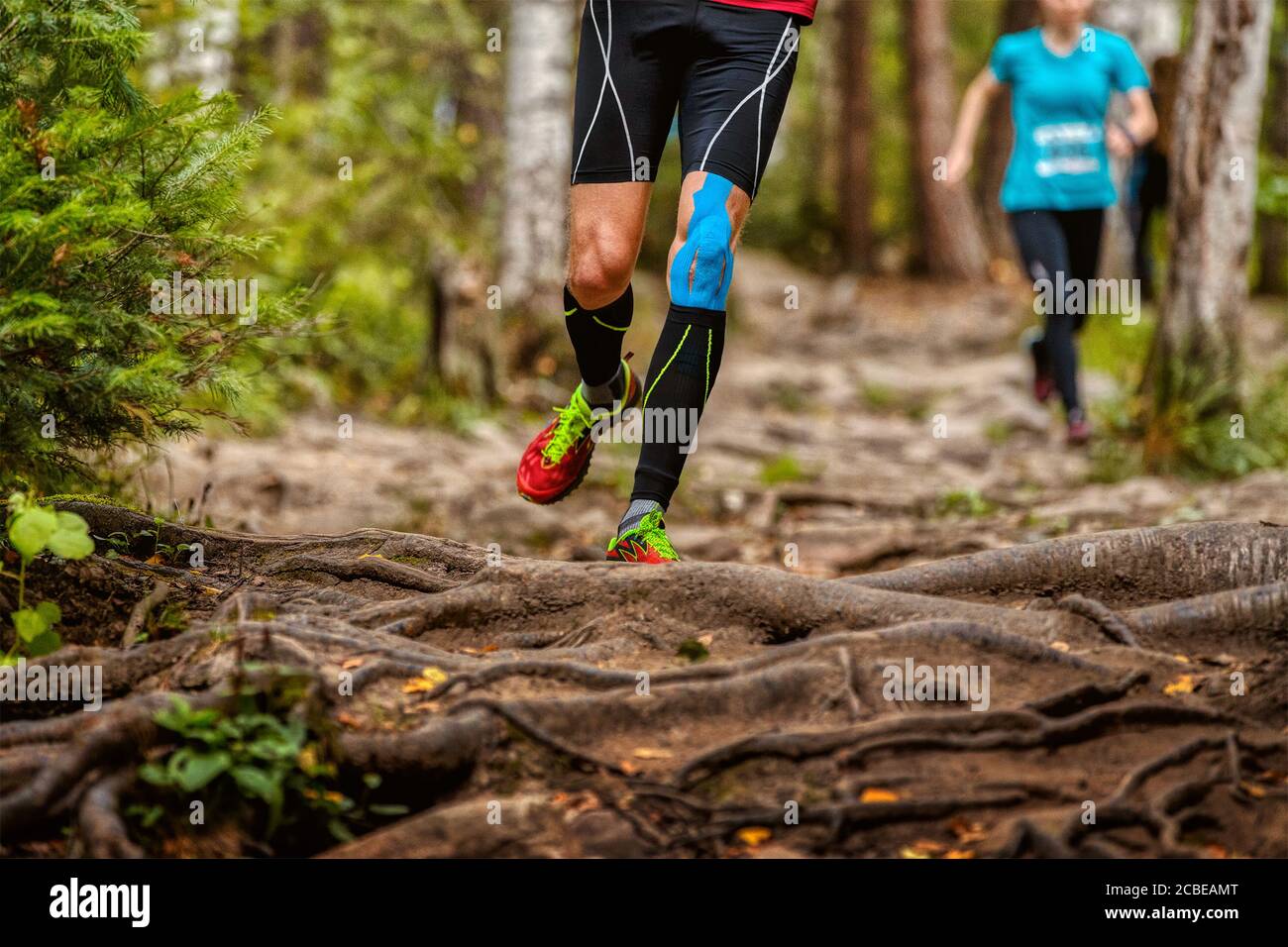 Beine Mann Läufer in Kompressionssocken und Kinesio Taping auf Knee Run Waldlehrpfad Stockfoto