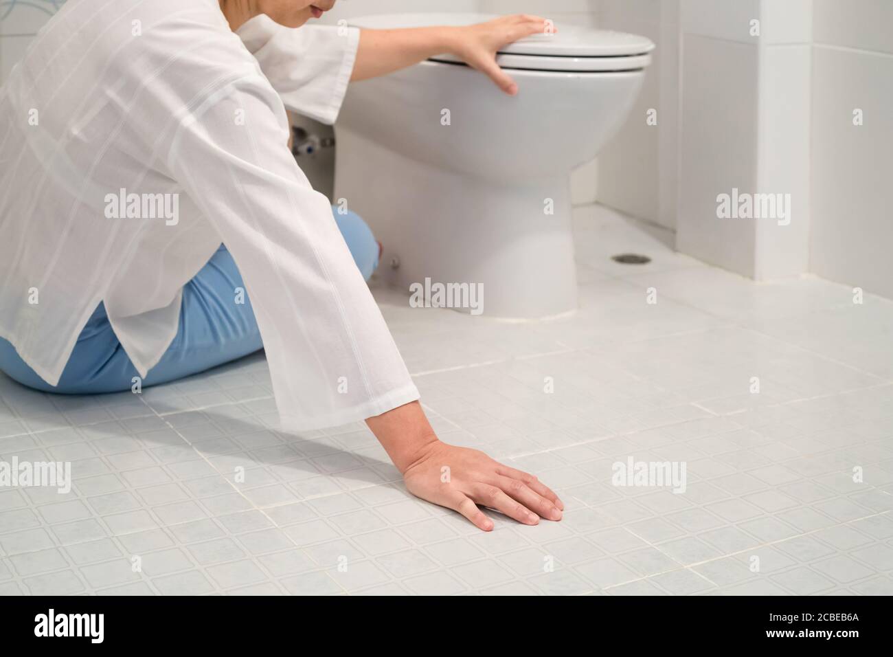 Ruhestand Frau fiel in eine Toilette Stockfoto