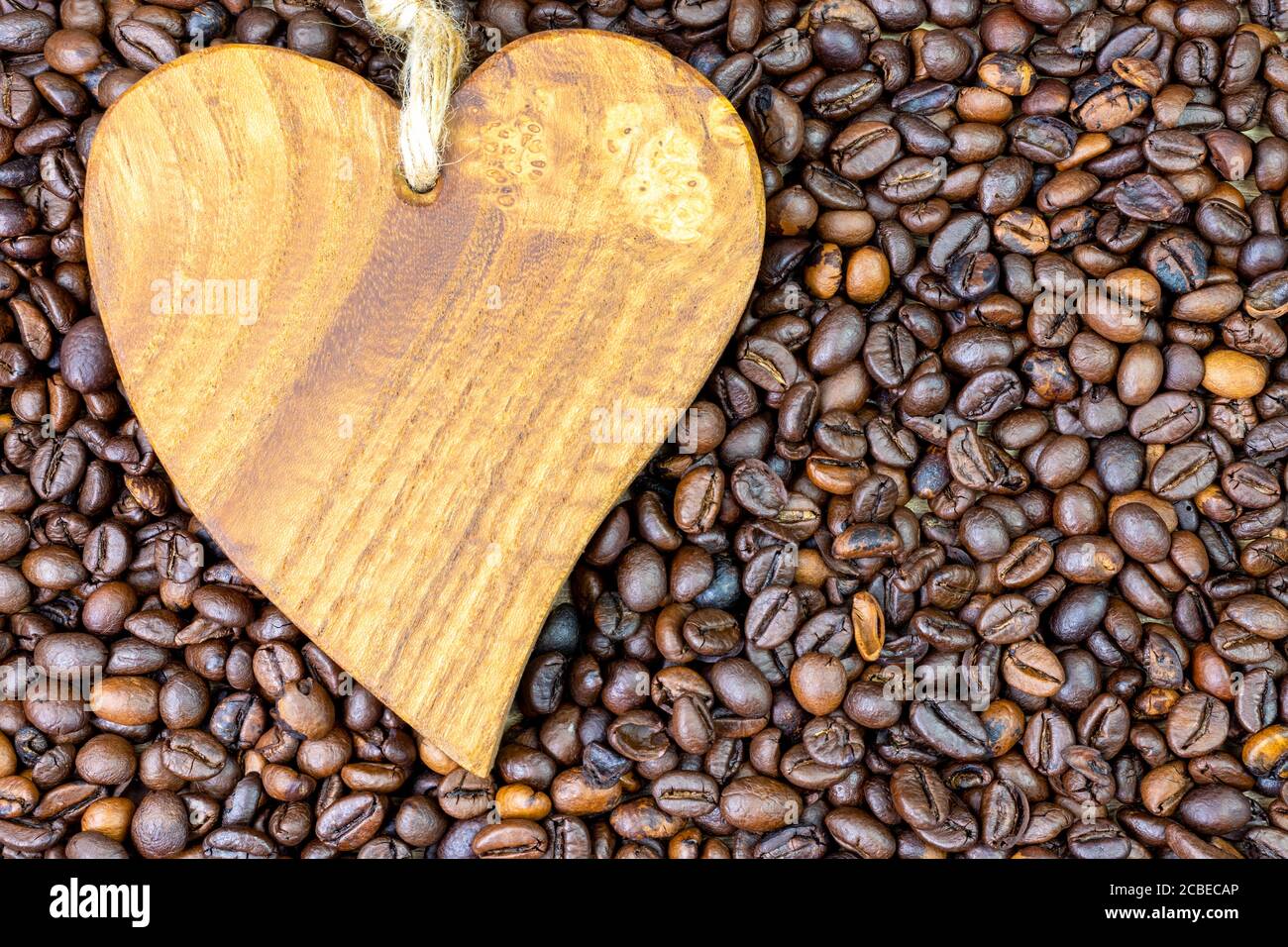 Holzherz auf gerösteten Kaffeebohnen Hintergrund Stockfoto
