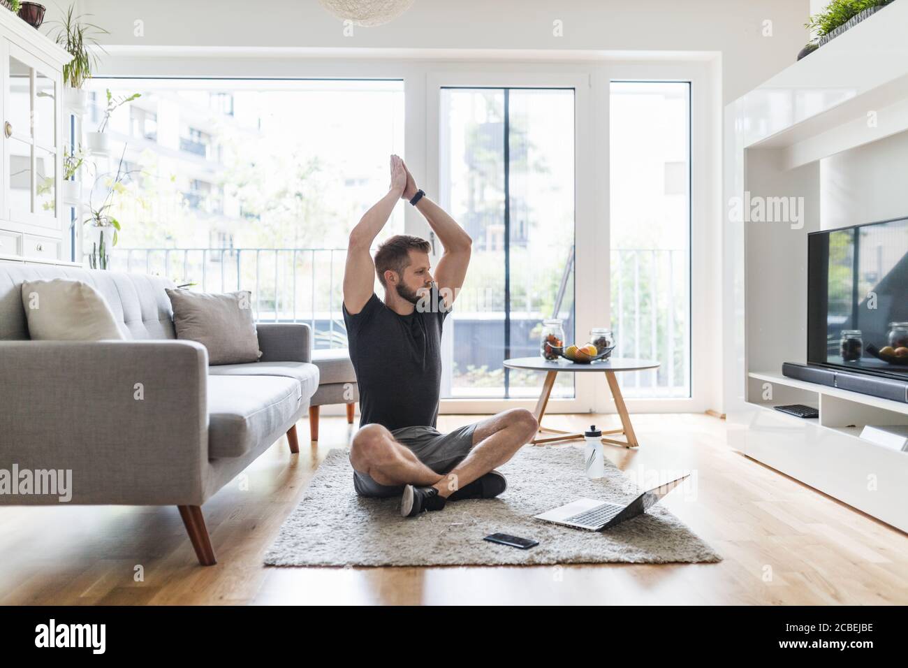 Hübscher junger Mann, der zu Hause im Wohnzimmer arbeitet Zimmer Stockfoto
