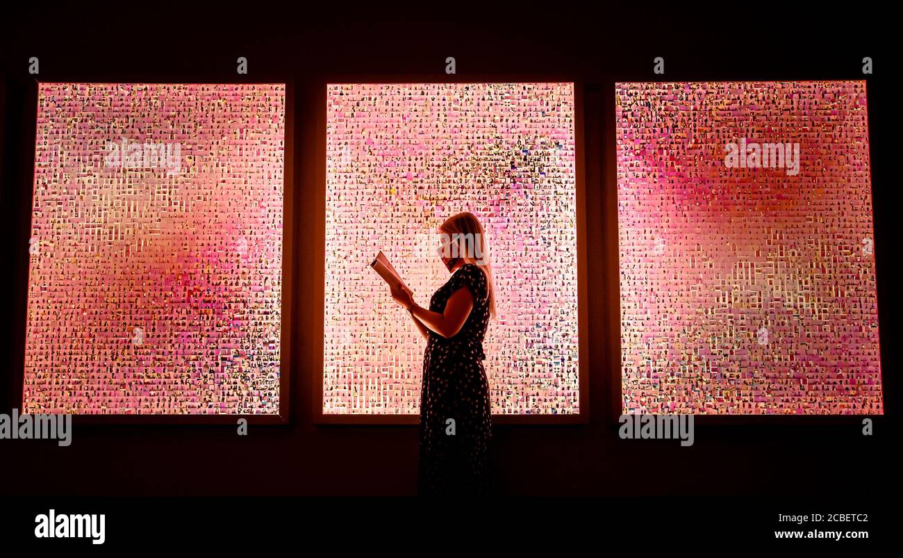 Ein Besucher liest ein Programm vor einer Arbeit mit dem Titel 'Murations #23: 10,000 Selfies (with a pink Wall in Los Angeles)' der Künstlerin Stephanie Potter Corwin, die Teil der Ausstellung des Esthetica Art Prize ist, die in der York Art Gallery in Yorkshire zu sehen ist. Stockfoto