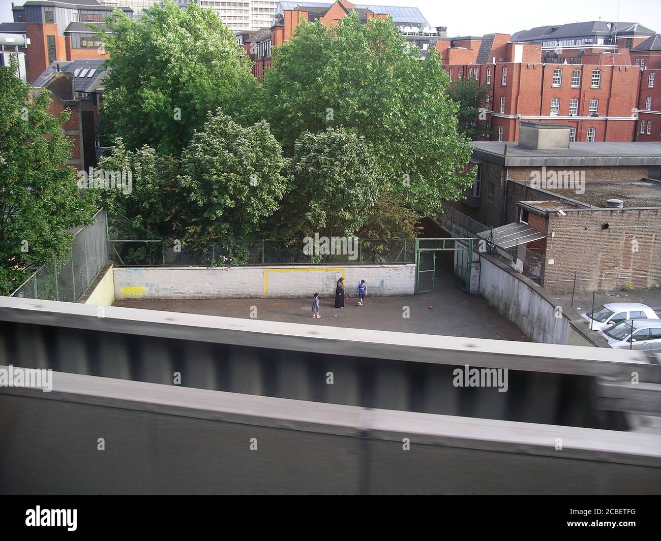 Mutter und Kinder spielen Fußball in der Stadt Umwelt Stockfoto