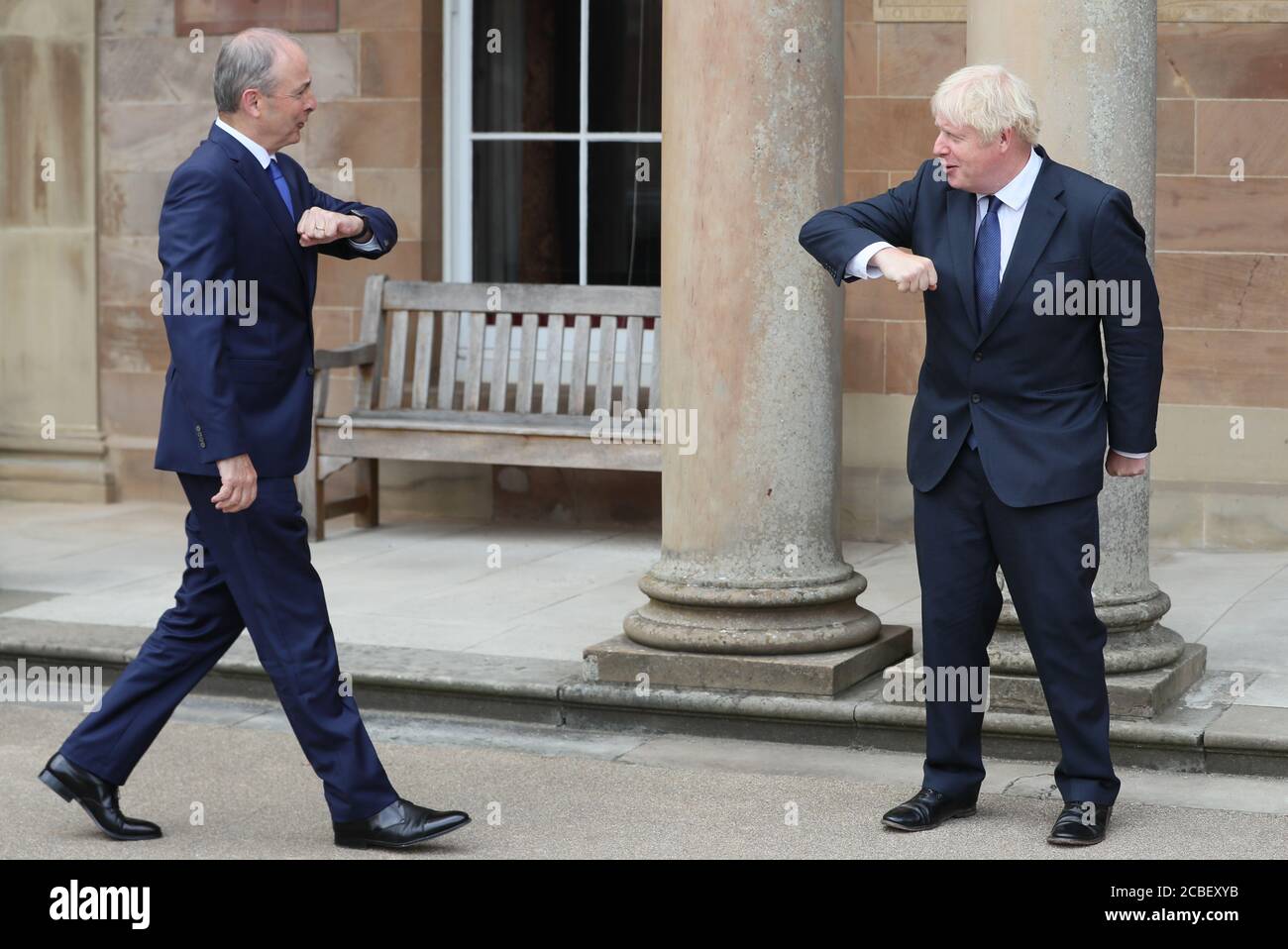 Premierminister Boris Johnson (rechts) und Taoiseach Micheal Martin begrüßen sich beim Besuch des Premierministers in Belfast mit einem Ellenbogenstoß im Hillsborough Castle. Stockfoto