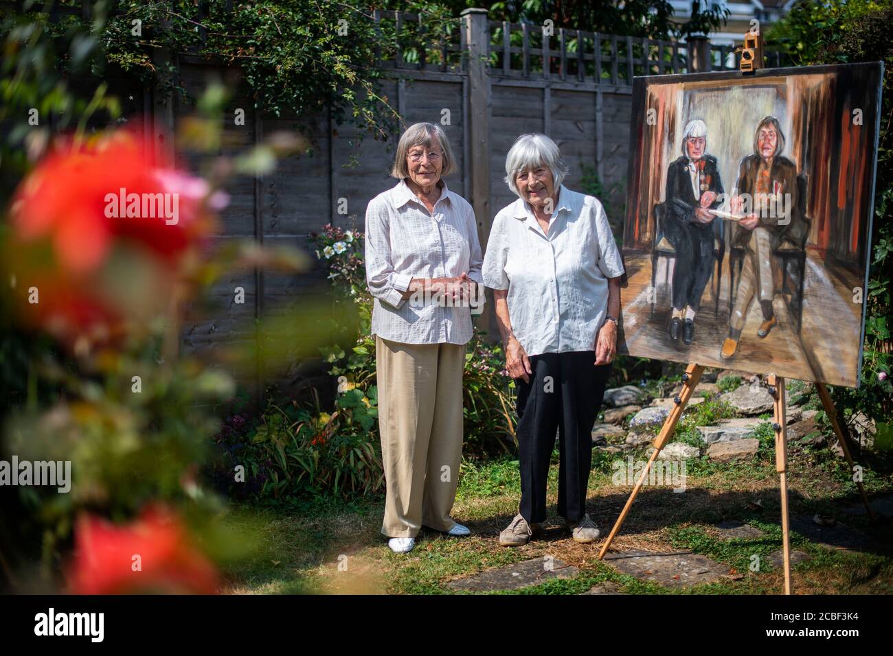 Jean Argles und Patricia Davie (L-R), die letzten lebenden Schwestern, die  beide im Zweiten Weltkrieg den Official Secrets Act unterzeichnet haben,  präsentieren ihr Porträt von Dan Llywelyn Hall im Westen Londons vor