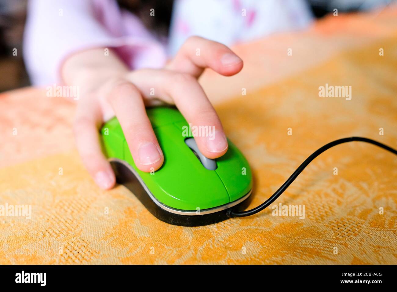 Hand auf einer Computermaus. Die Hand des Kindes leitet das Lernen mit Technik. Stockfoto
