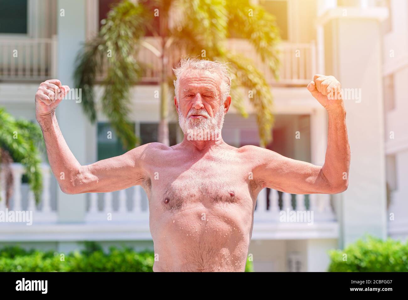 Starke gesunde ältere Mann zeigen Muskeln und fit Ausdruck im Freien Stockfoto