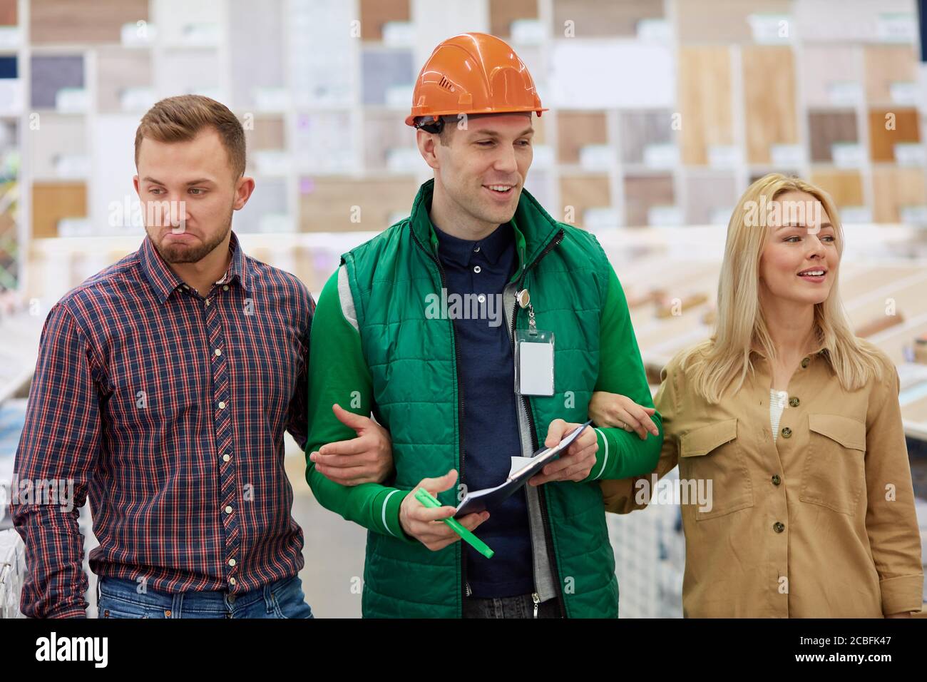 Angenehme Lagerarbeiter froh, Kunden zu helfen, baten sie um Beratung, Arbeiter lieben seinen Job, er ist sozial angepasst Stockfoto