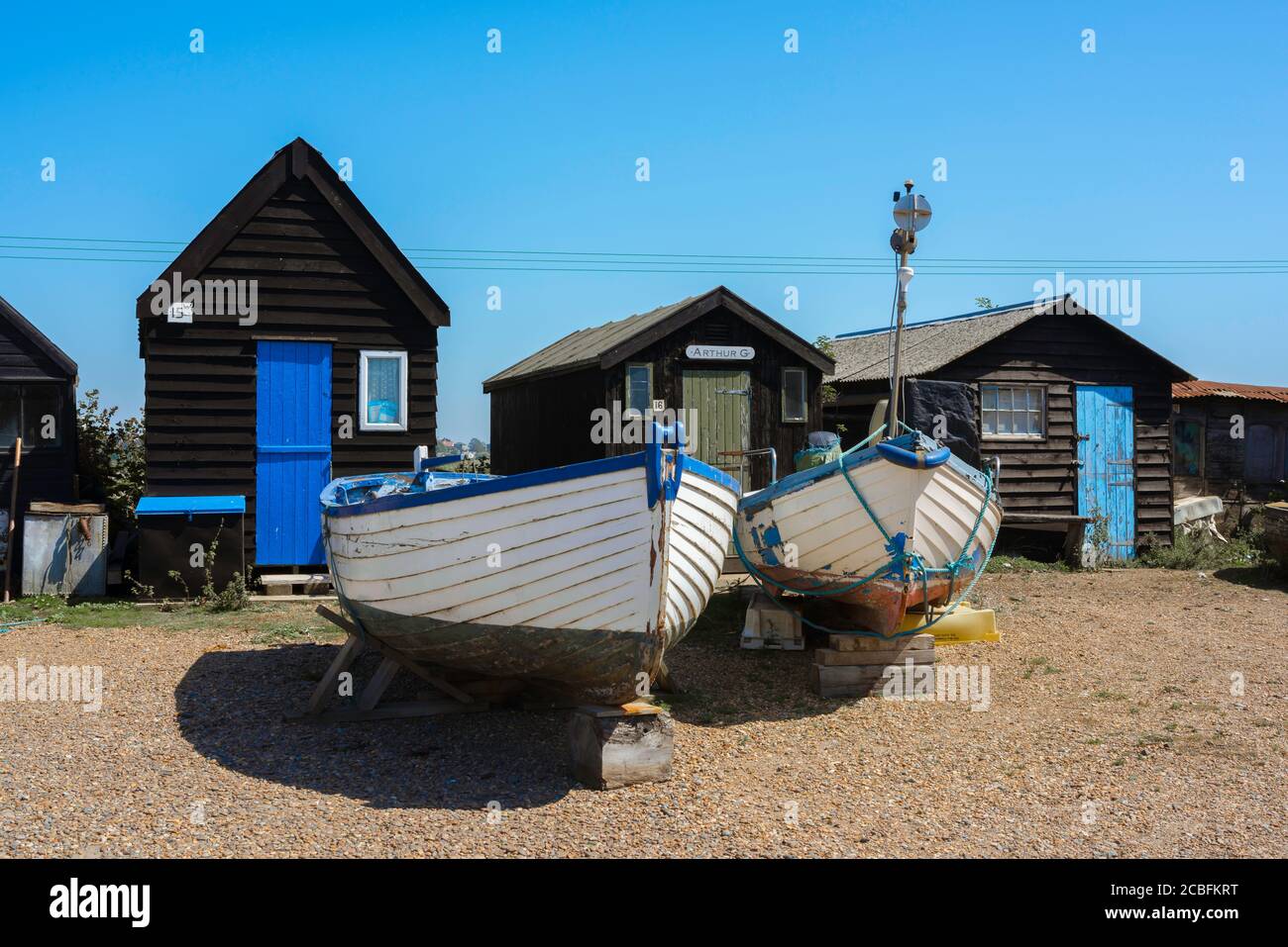 Britische Küste, Blick im Sommer auf ein Fischerboot und traditionelle Fischerhütten in Southwold Harbour, Suffolk, England, Großbritannien Stockfoto