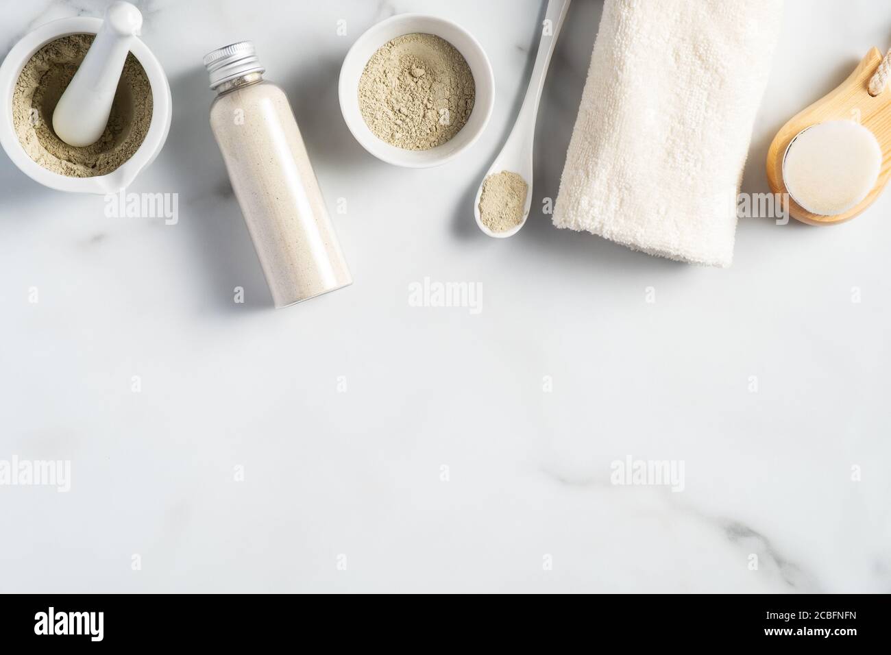 Ayurvedische Gesichtspackung/Maske mit Gram Mehl/Bean, haldi Ubtan in Schüsseln platziert, Peeling und weißem Handtuch auf Marmortisch. Stockfoto