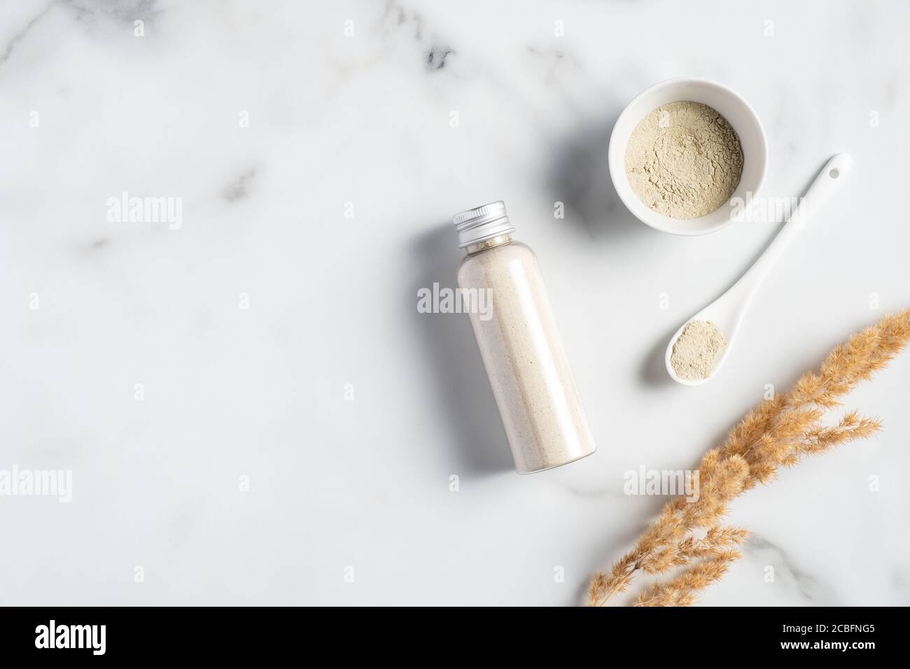 Ayurvedische Gesichtspackung/Maske mit Gram-Mehl/Besan, haldi-Ubtan in Schale, Gesichtspeeling auf Marmortisch. Naturkosmetik. Stockfoto