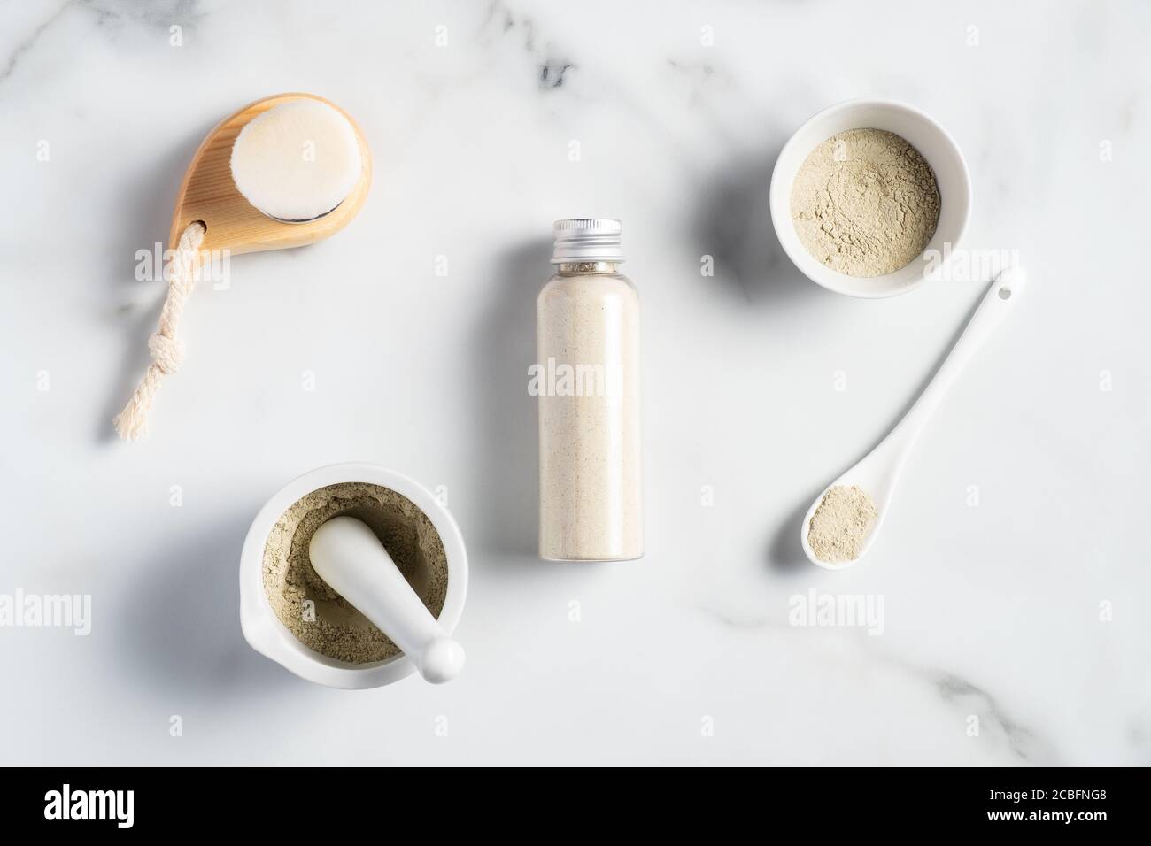 Ayurvedische Gesichtspackung/Maske mit gram Mehl/Bean, haldi Ubtan in Schale, Peeling und Reinigungsbürste auf Marmortisch. Bio-WELLNESS-Beauty-Produkt. Stockfoto