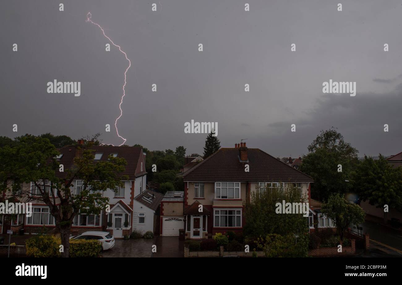 Wimbledon, London, Großbritannien. 13. August 2020. Sintflutartige Regenfälle und Gewitter kommen schließlich in London an, mit Gabelblitzen hinter Häusern in Merton. Quelle: Malcolm Park/Alamy Live News. Stockfoto