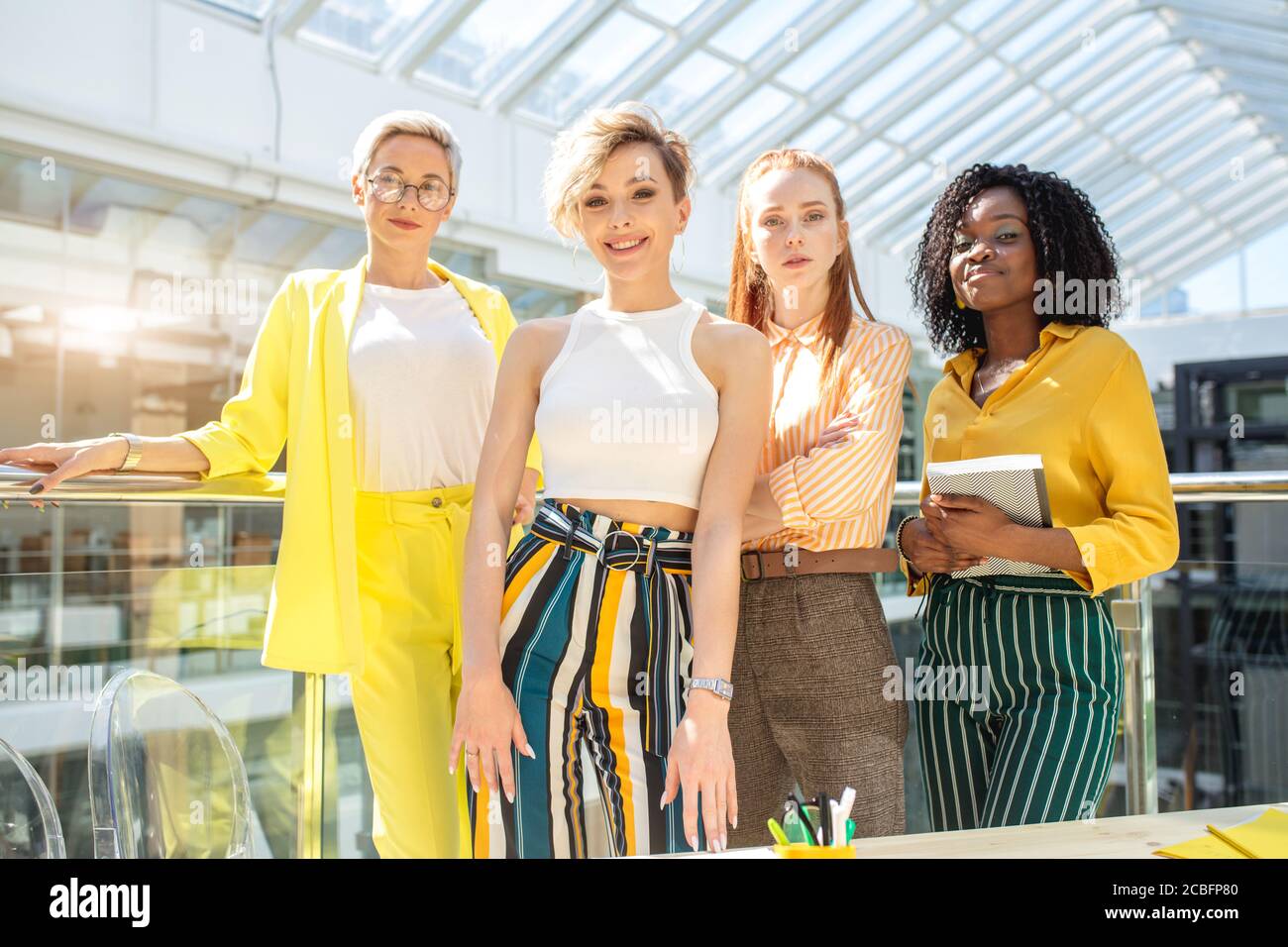 Glückliche Geschäftsfrauen stehen in einer Reihe im Büro. Frauengesellschaft. Bedeutung der Frau in der Gesellschaft. Angenehme Frau Unternehmen Stockfoto