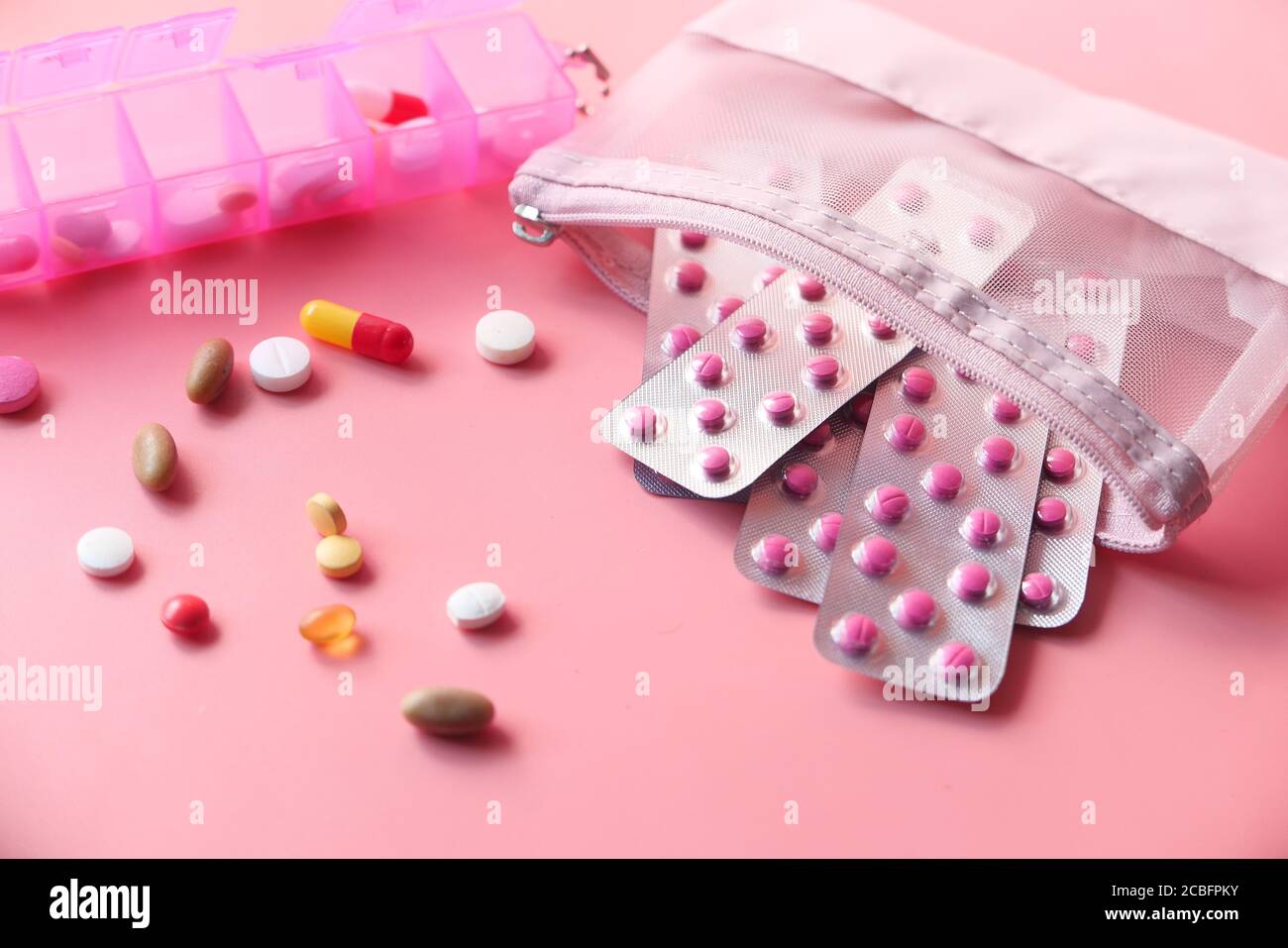 Nahaufnahme von bunten Pillen und Blisterpackung auf rosa Hintergrund Stockfoto