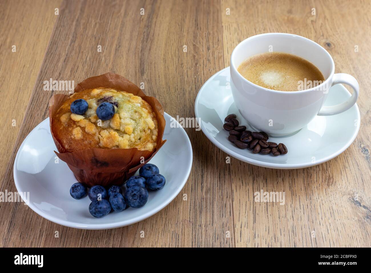 Blaubeer Muffin und Tasse Kaffee auf Holztisch Stockfoto
