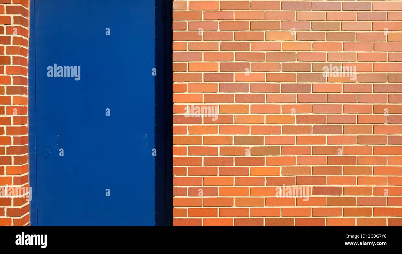 Rote Ziegelwand mit blauer Tür Stockfoto