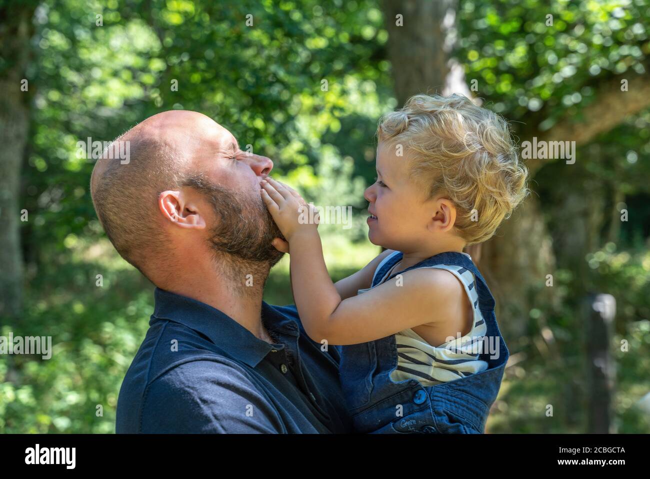 Vater und kleiner Sohn spielen im Wald Stockfoto