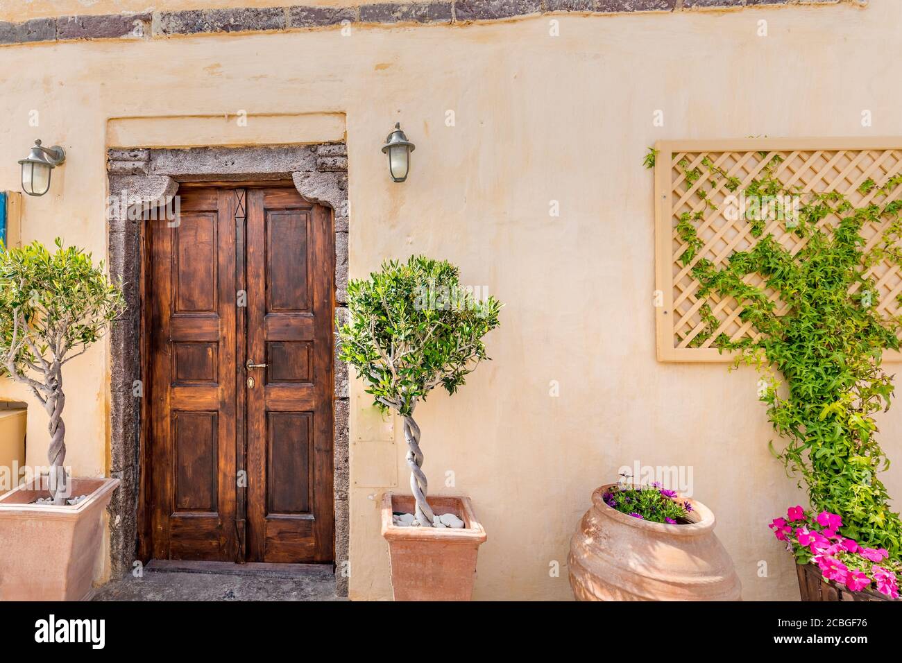 Alte charmante Straßen, Südfrankreich, Provence. Alte Holztür mit Bougainvillea Blumen und grünen Pflanzen in Keramikvasen Stockfoto