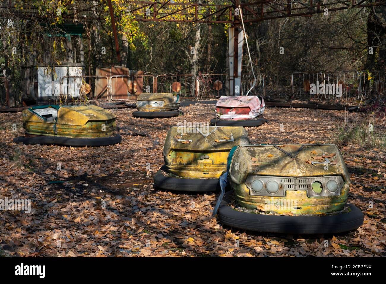 Alte zerbrochene rostige Metall radioaktive gelbe Autos, Kinder-Elektroautos, Erholungspark in der Stadt Pripjat, Tschernobyl-Katastrophe, Ukraine Stockfoto