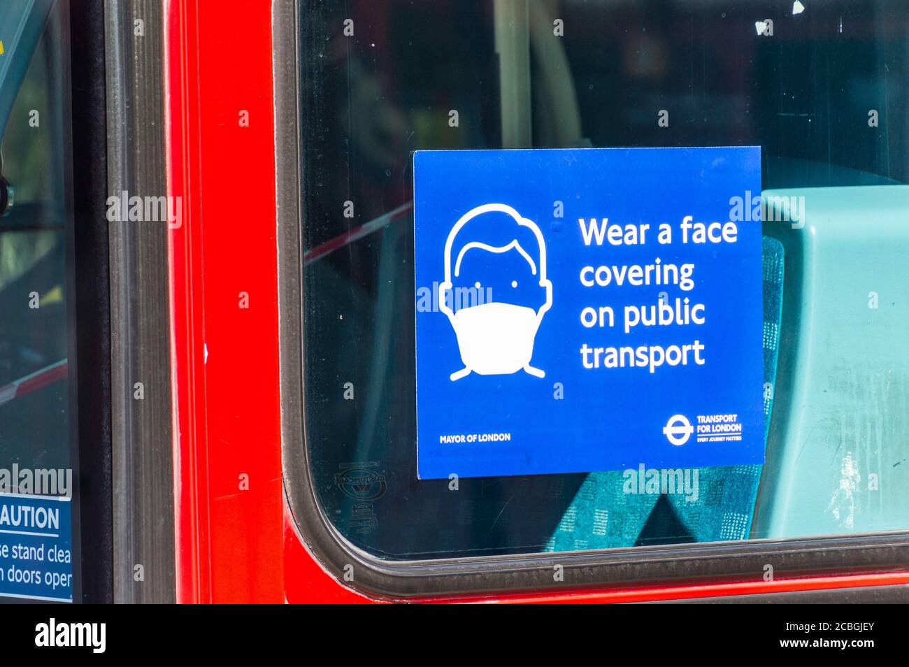 Tragen Sie eine Gesichtsbedeckung auf öffentlichen Verkehrsmitteln Poster auf London Bus während der covid 19 oder Coronavirus Pandemie Stockfoto