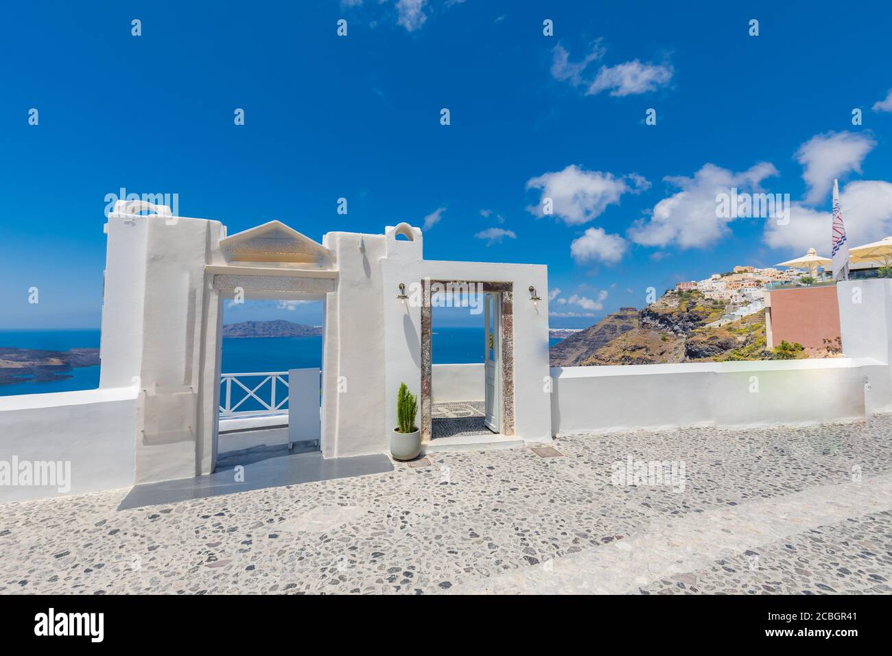 Santorini Island, Griechenland. Traditionelle griechische Tür mit einer tollen Aussicht. Erstaunliche Meereslandschaft über Klippen mit Holztür und traditioneller weißer Architektur Stockfoto
