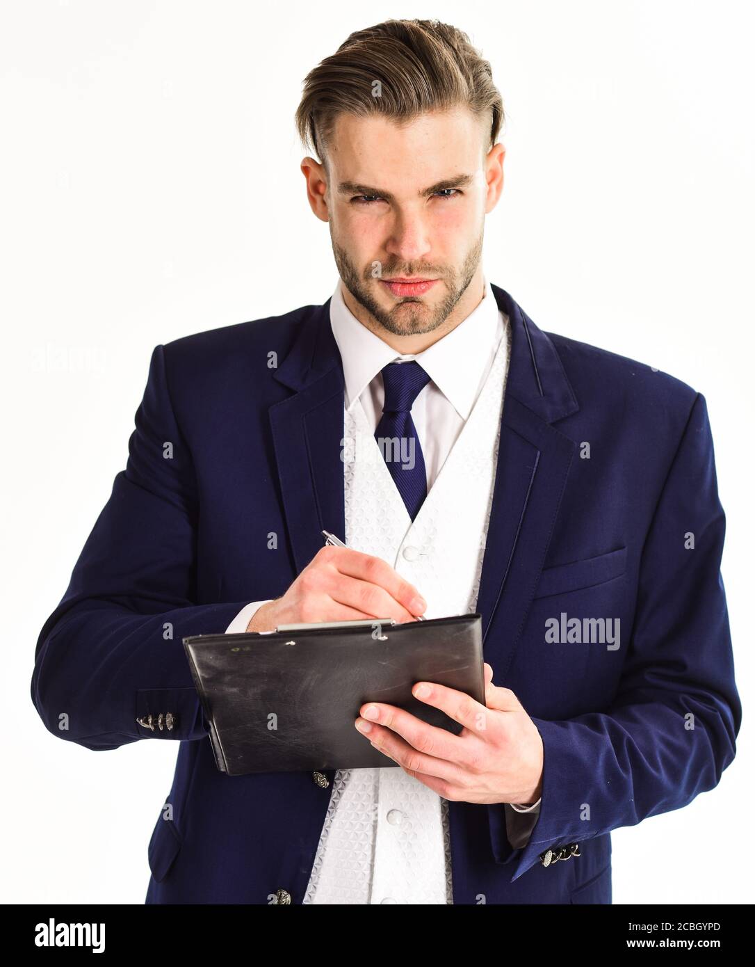 Geschäftsmann mit jungem Aussehen und klassischem Outfit hält Pad und Stift. Mann in Anzug oder Geschäftsmann mit ernsten Gesichtszeichen Dokument von Stift auf weißem Hintergrund. Geschäftsdokumente Konzept. Stockfoto
