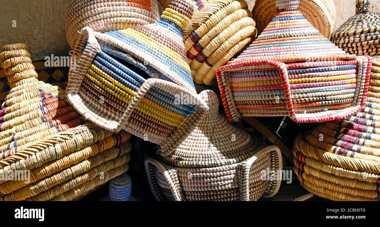 Ein Stapel farbenfroher dekorativer Schilfrohr-Tagine in der alten Medina von Fez, Marokko. Der Tajine ist eine kulturelle Ikone, die mit dem Kochen in Marokko verbunden ist. Stockfoto