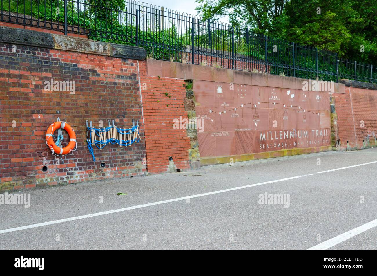 Seacombe, UK: 23. Jun 2020: Architektonische Kunst eines Rettungsrings und einer Fluchtleiter werden an einer roten Ziegelwand neben einem Planogramm des Millennium T befestigt Stockfoto