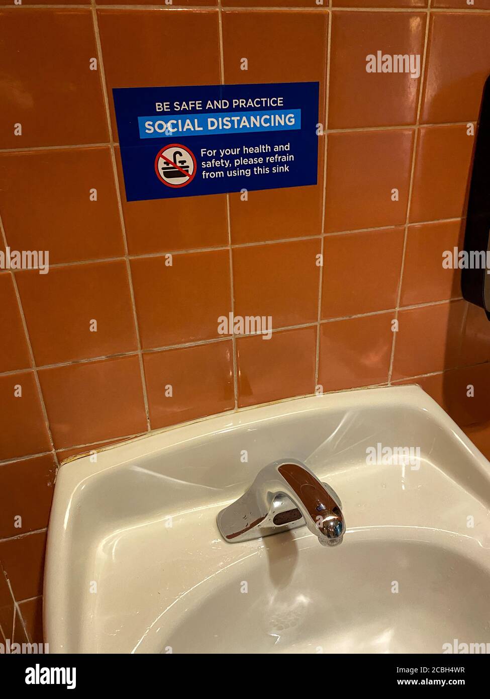 Orlando, FL/USA- 6/13/20: Ein Schild, das die Gäste der Universal Studios in Orlando, Florida auf soziale Distanz warnt und davon absieht, ein Waschbecken in einer Badewanne zu benutzen Stockfoto
