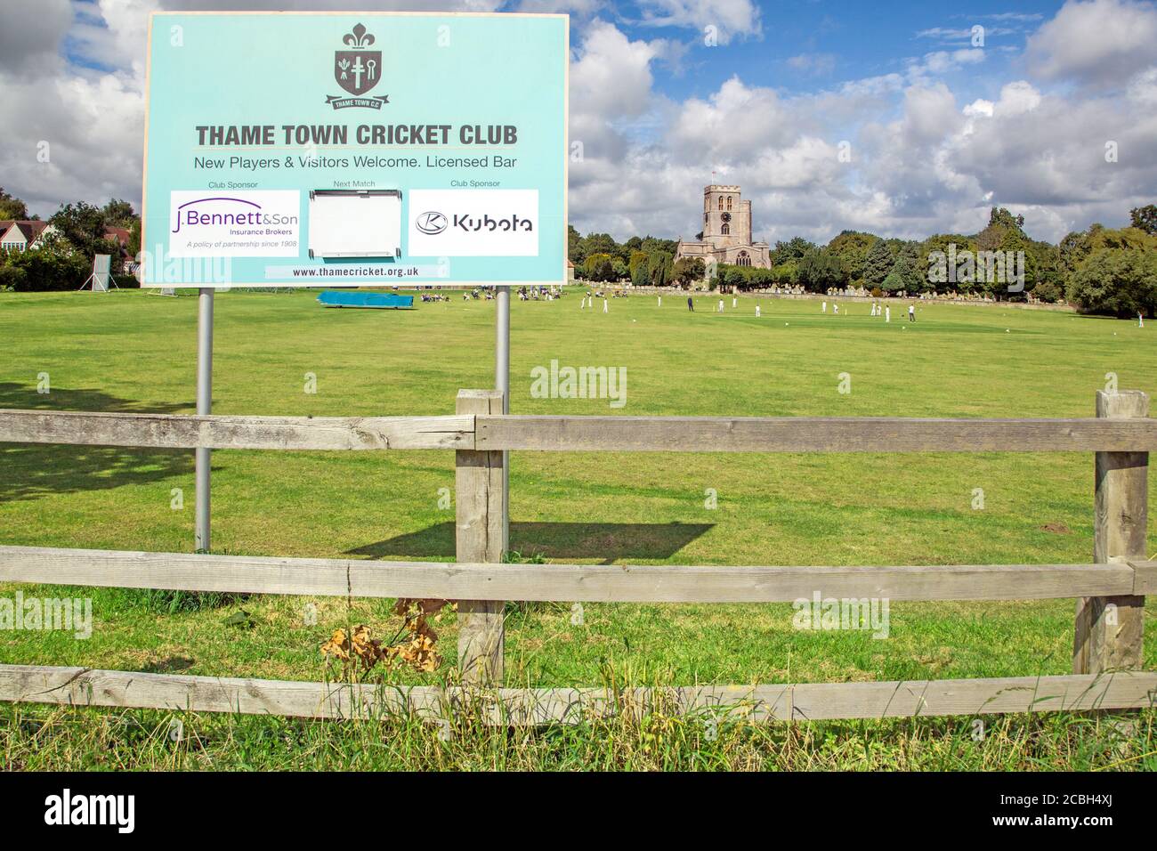 Cricket-Spiel auf der malerischen Kirchweide das Zuhause Thame Cricket Club Oxfordshire England mit St. Mary's Kirche in Der Hintergrund Stockfoto