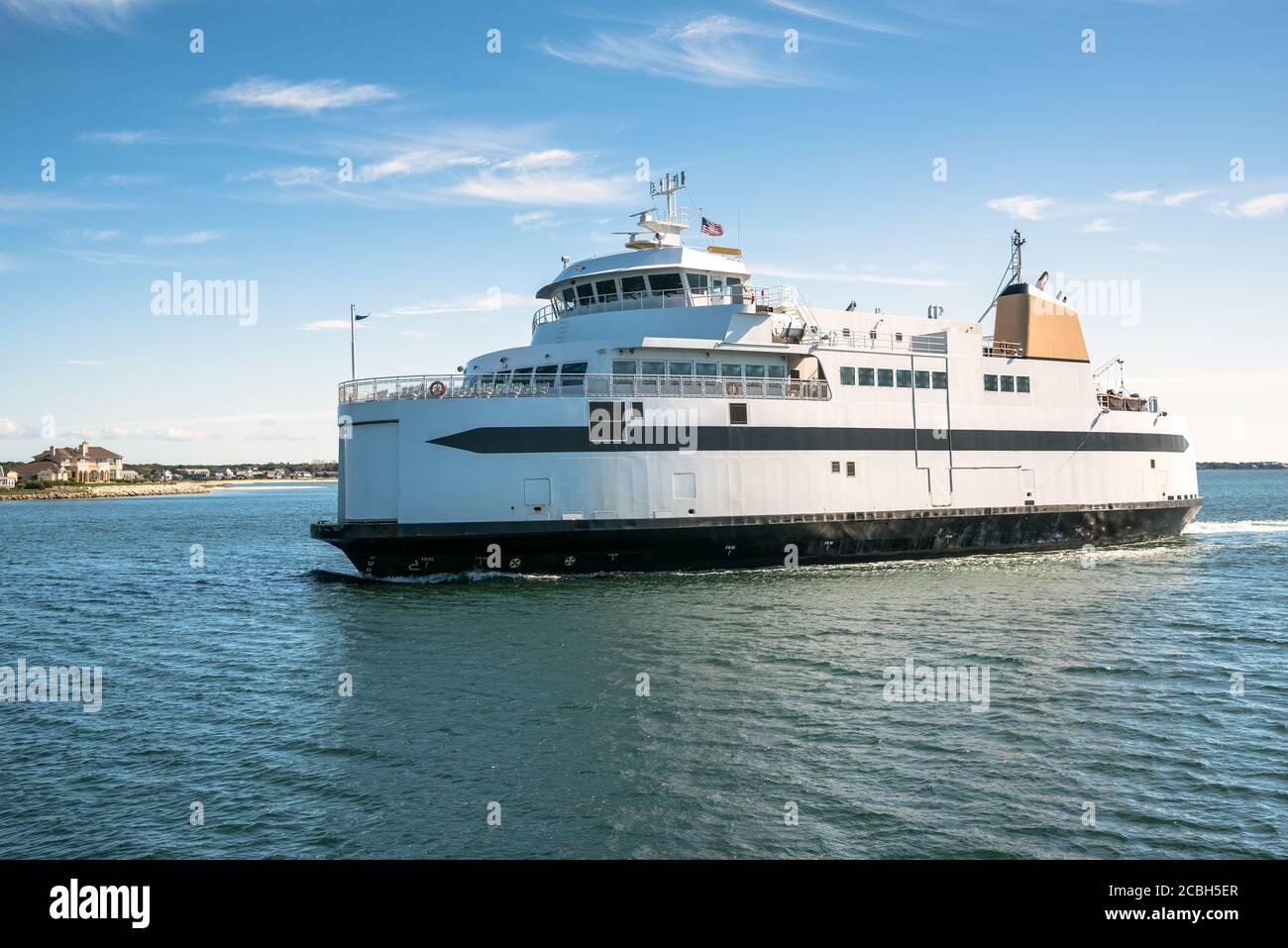 Fähre segelt nahe der Küste an einem sonnigen Herbsttag Stockfoto